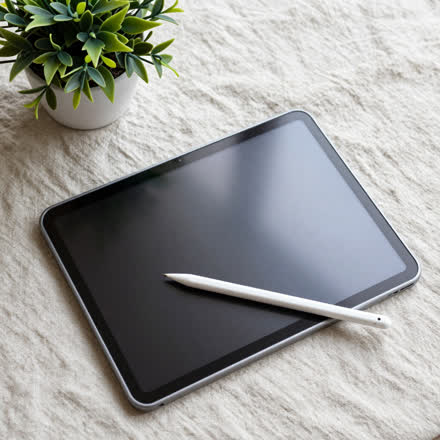 Tablet com caneta apoiado numa superfície de linho.